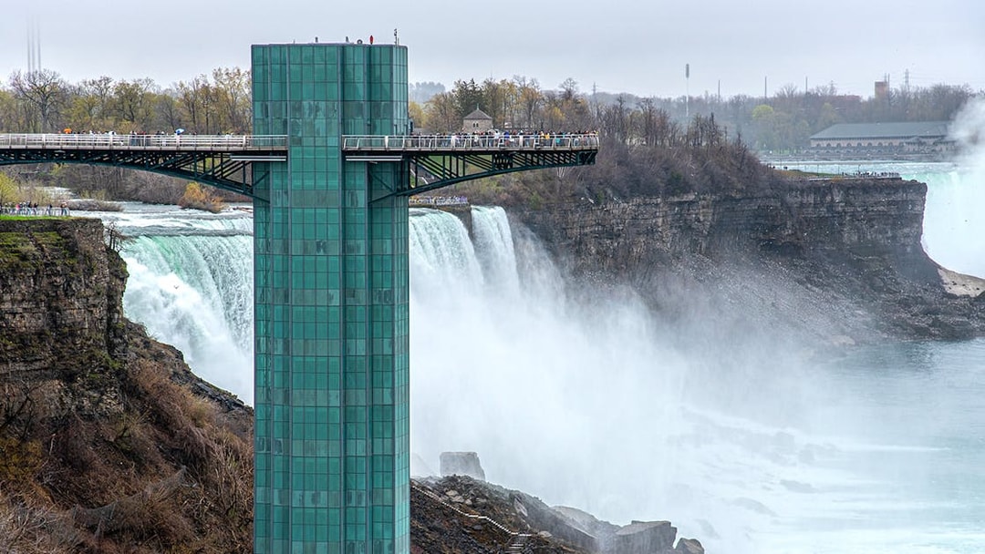 Observation deck overlooking Niagara Falls with mist and surrounding cliffs.