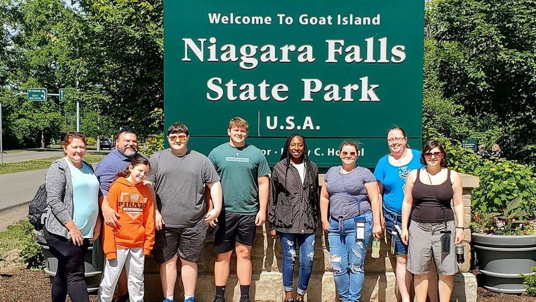 Group at Niagara Falls State Park entrance, New York, near Maid of the Mist and Cave of the Winds tours.