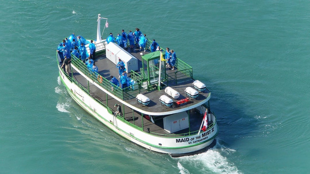 Aerial view of Maid of the Mist cruise boat with passengers in blue ponchos.