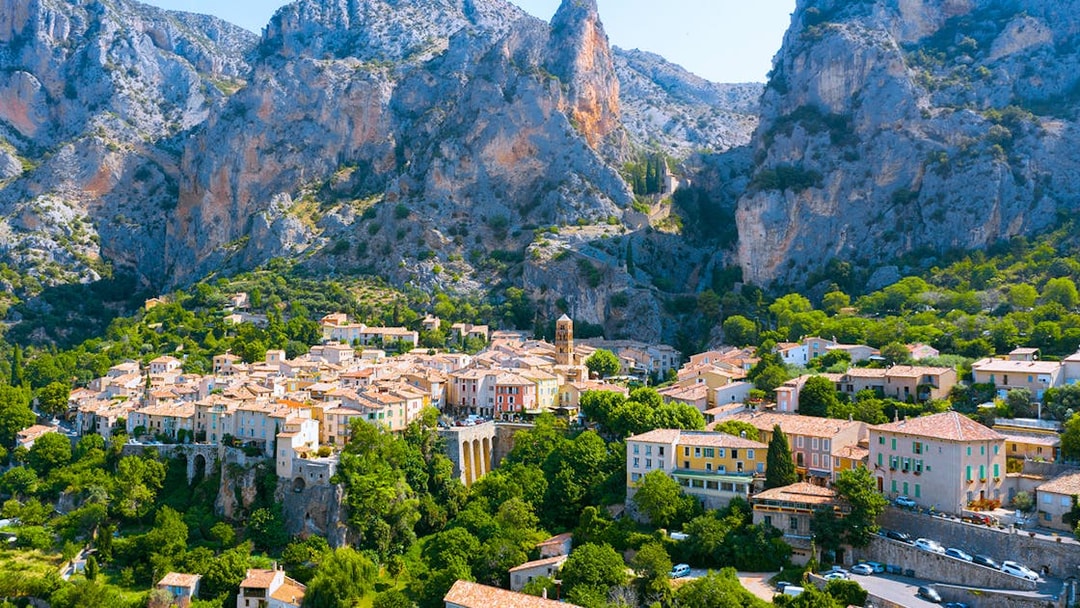 Village nestled in the Gorges du Verdon with rocky cliffs and greenery, France.