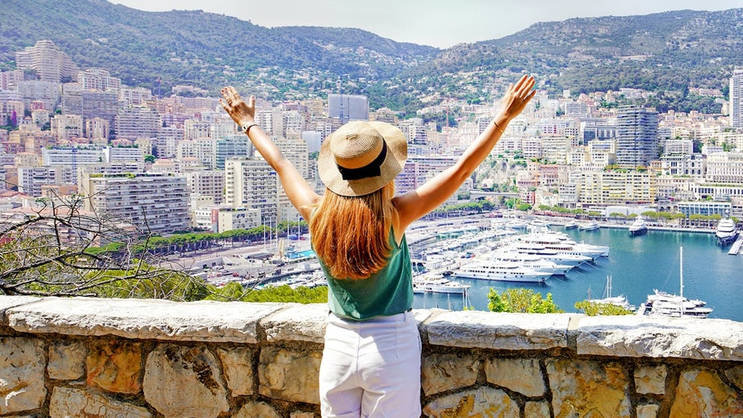 Tourist overlooking Monte Carlo harbor and cityscape in Monaco.