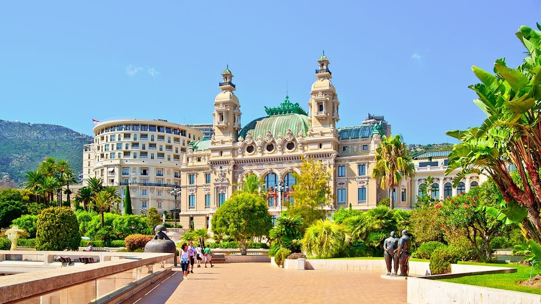 Monte Carlo Casino exterior with gardens and sculptures in Monaco.