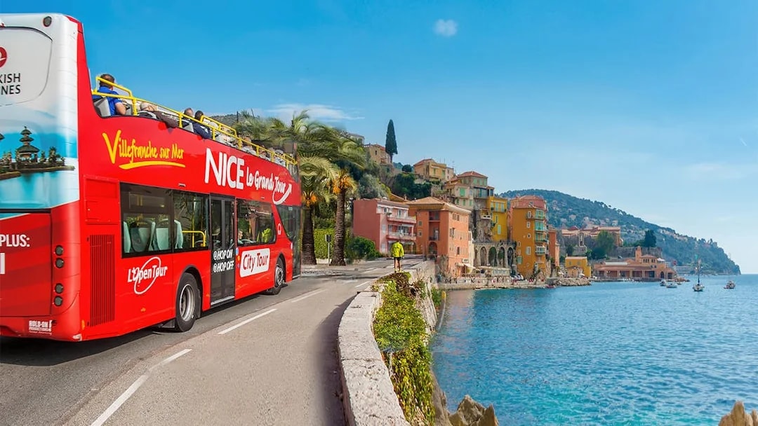 Nice city tour bus on Promenade des Anglais with coastal view.