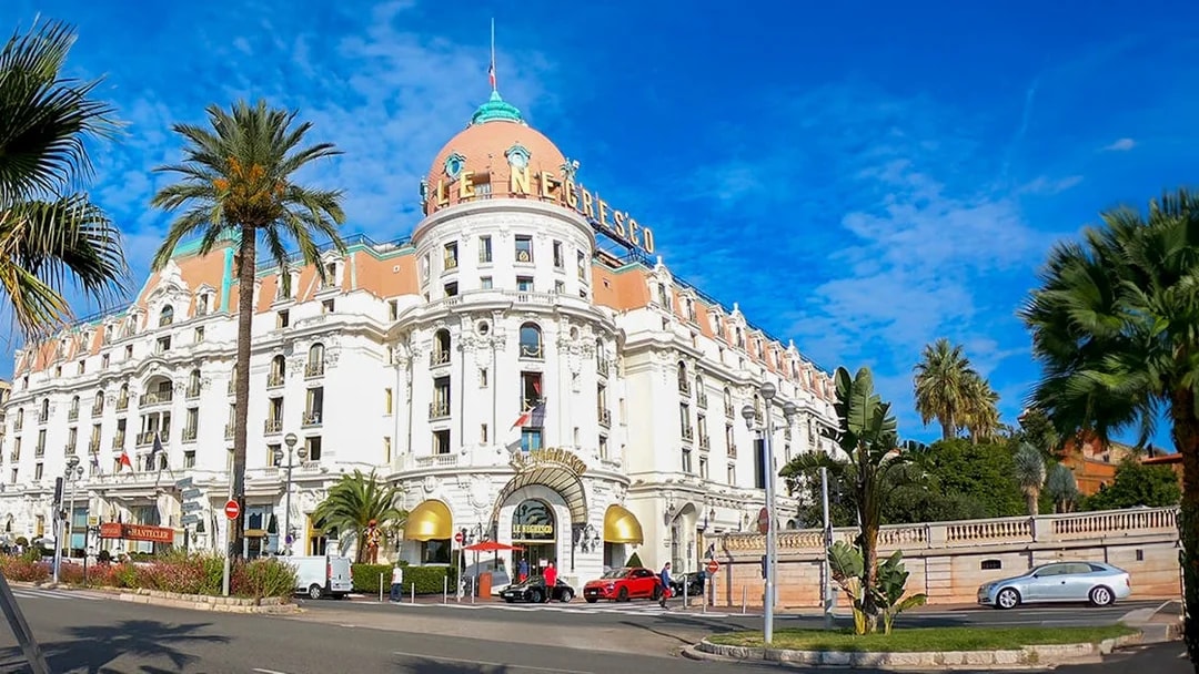 Hotel Negresco's grand facade with palm trees, Nice City.