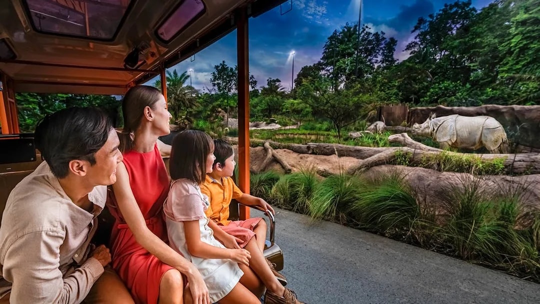 Family on tram viewing rhinoceroses during Singapore Night Safari.