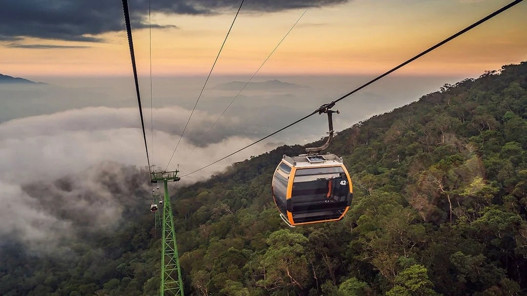 Cable car ascending over lush forest at Sun World Ba Na Hills, Vietnam.