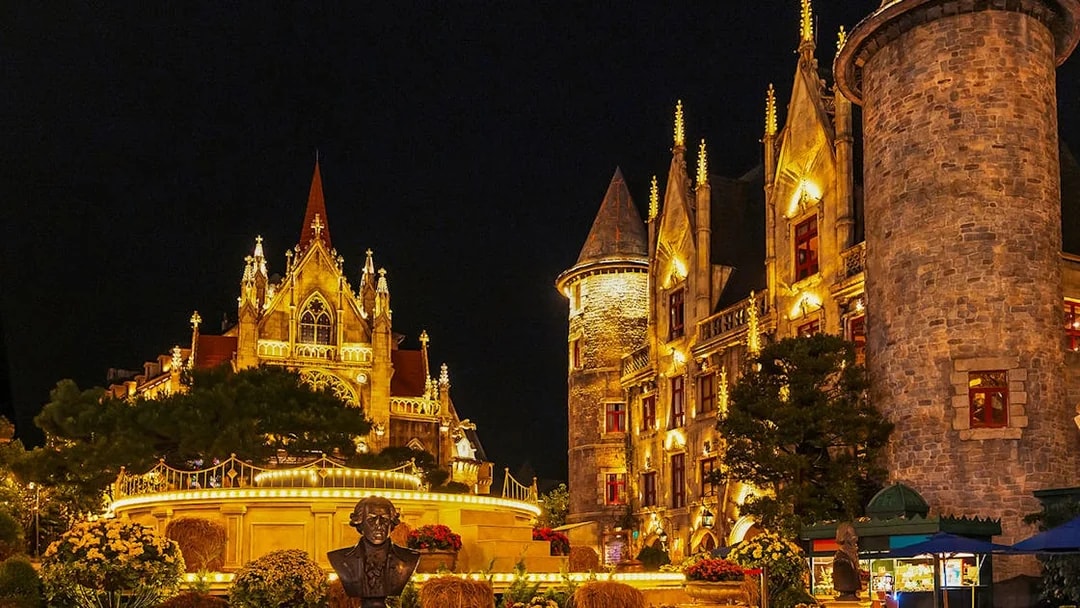 Catholic Cathedral and stone castle illuminated at night in Ba Na Hills Park, Da Nang, Vietnam.