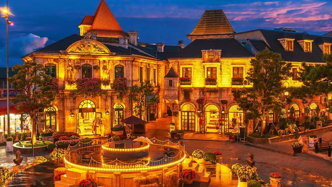 Central square in medieval French village at Ba Na Hills Park, Da Nang, illuminated at dusk.