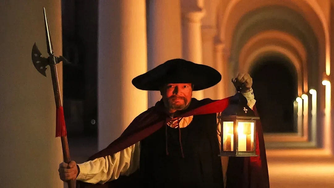 Night watchman holding lantern during guided tour in Dresden.