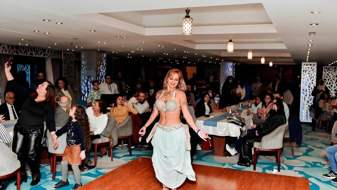 Belly dancer performing on a Nile River dinner cruise with guests watching.