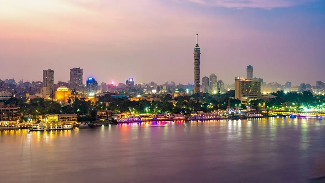 Cairo skyline at dusk with the Nile River and Cairo Tower in view.