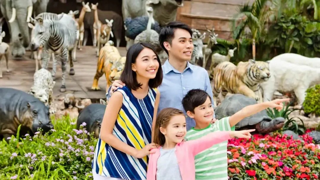 Family enjoying Noah's Ark with animal sculptures in the background.