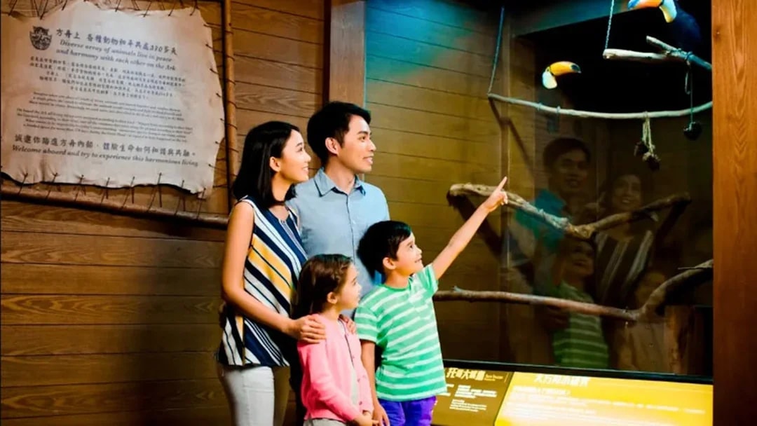 Family observing toucans at Noah's Ark exhibit.