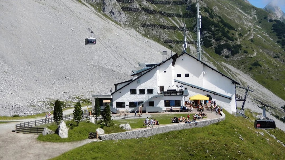 Cable car arriving at mountain station with visitors on terrace, Top of Innsbruck PLUS.