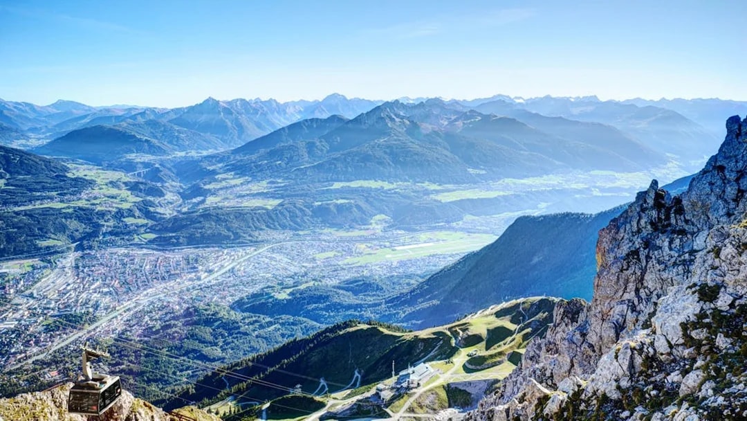 Aerial view of Innsbruck with mountains and a cable car station, Austria.