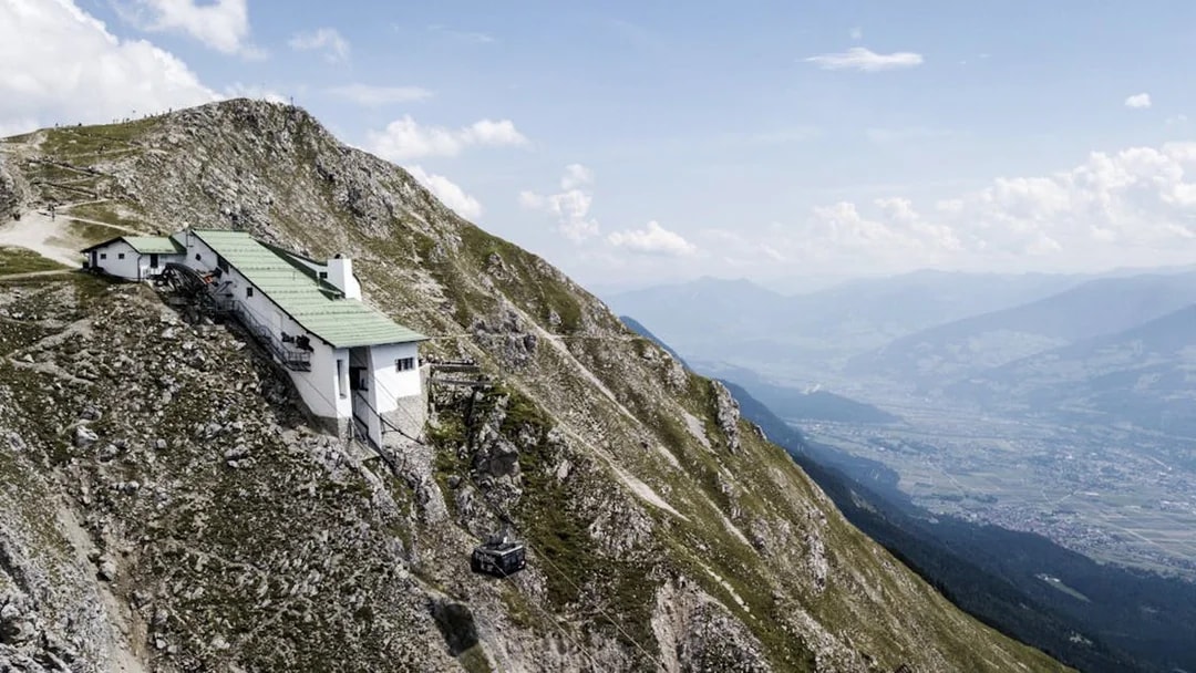 Mountain hut on Nordkette with cable car, overlooking Innsbruck valley, Austria.