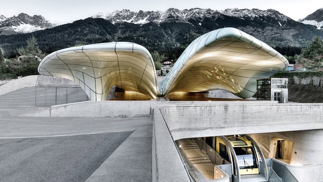 Hungerburgbahn funicular station with futuristic design in Innsbruck, Austria, against mountain backdrop.