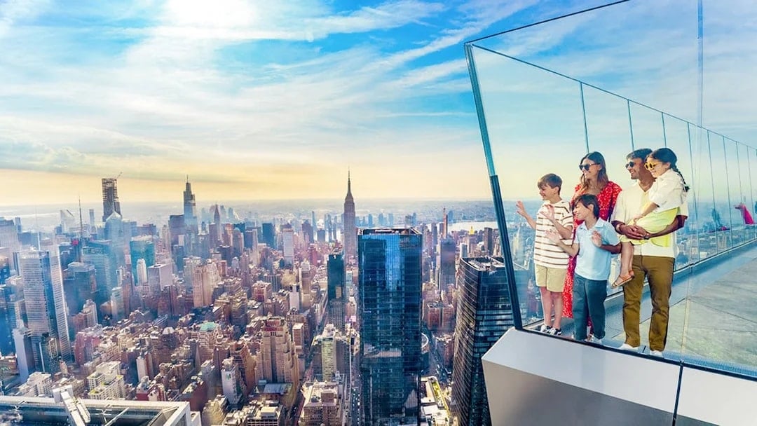 Family enjoying view from NYC observation deck with skyline and Empire State Building.