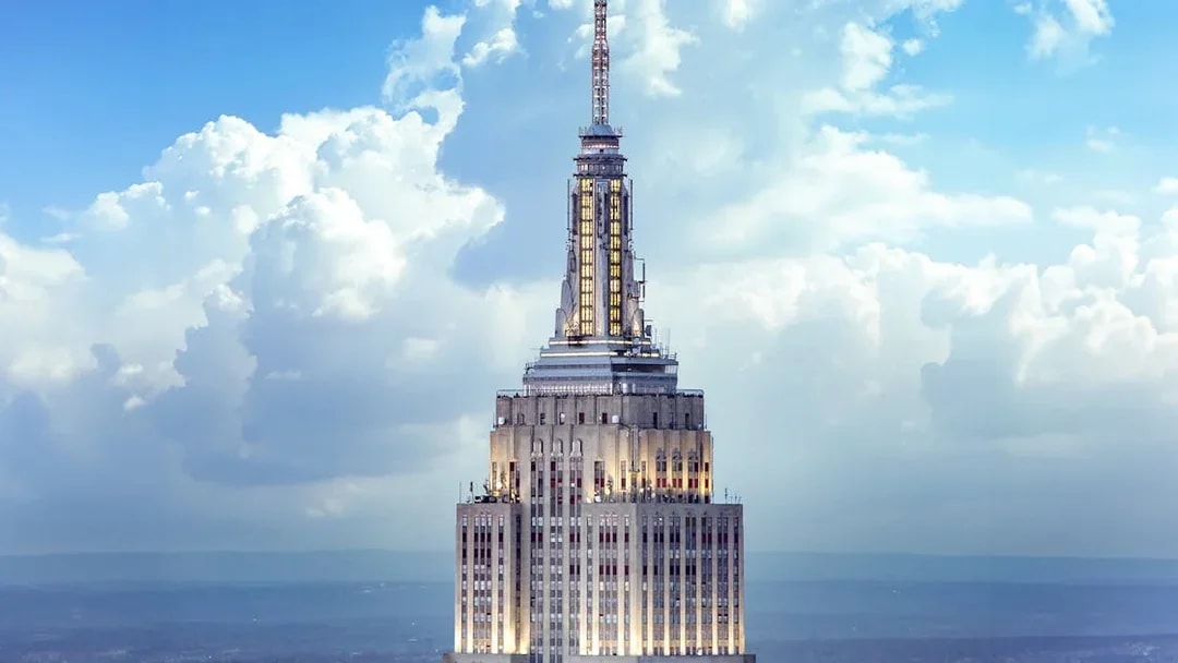 Empire State Building spire against a cloudy sky, New York City.