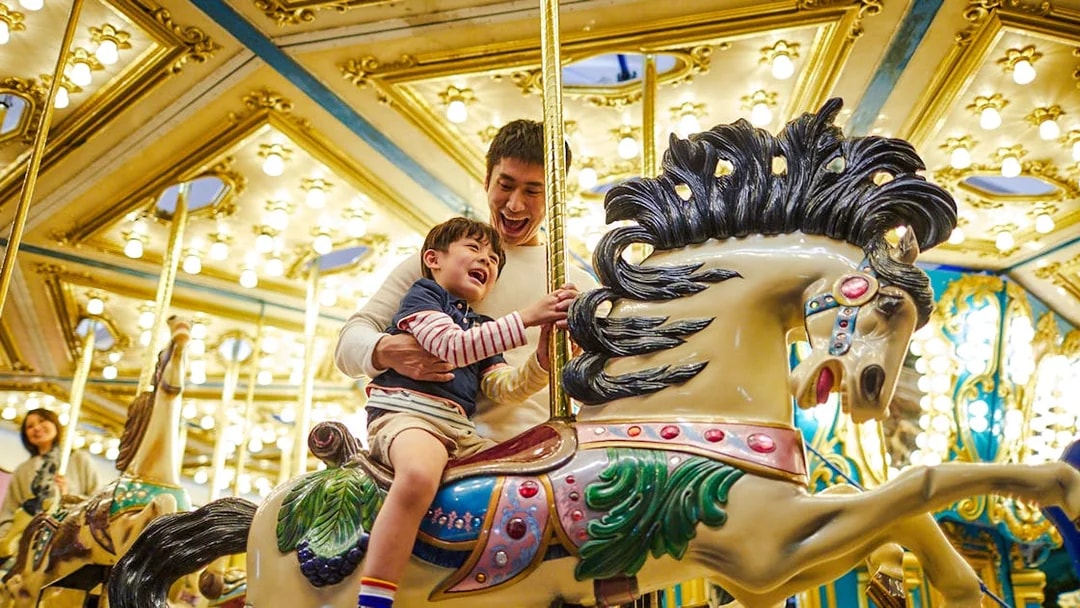 Father and child enjoying a carousel ride at Ocean Park Hong Kong.