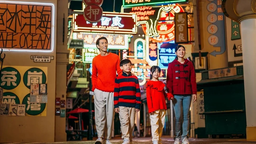 Family walking through neon-lit street at Ocean Park Hong Kong.