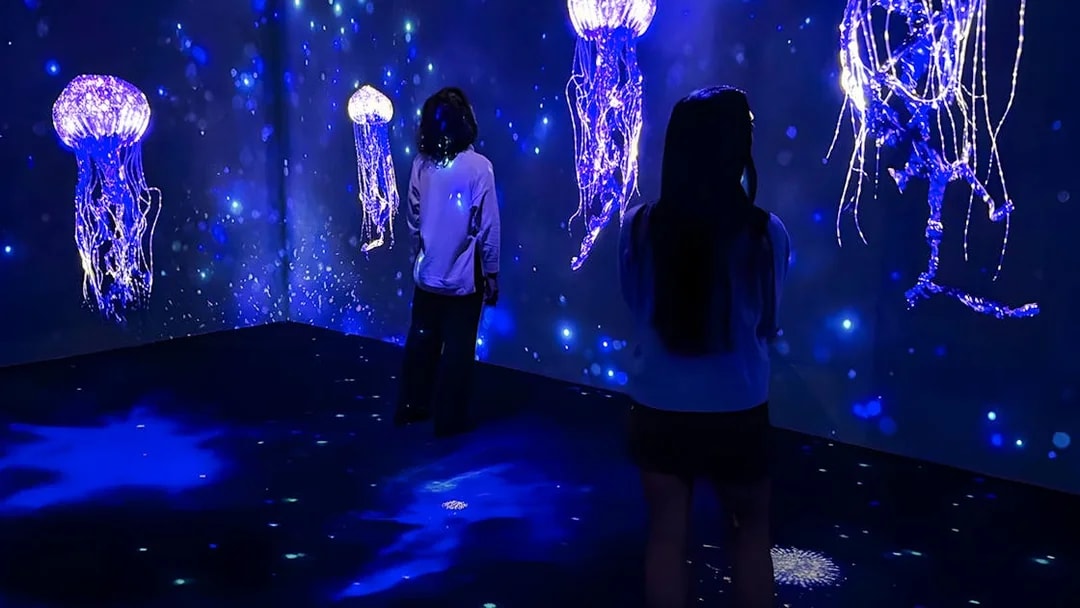 People viewing jellyfish display at Lisbon Oceanarium's Submerged Universe exhibit.