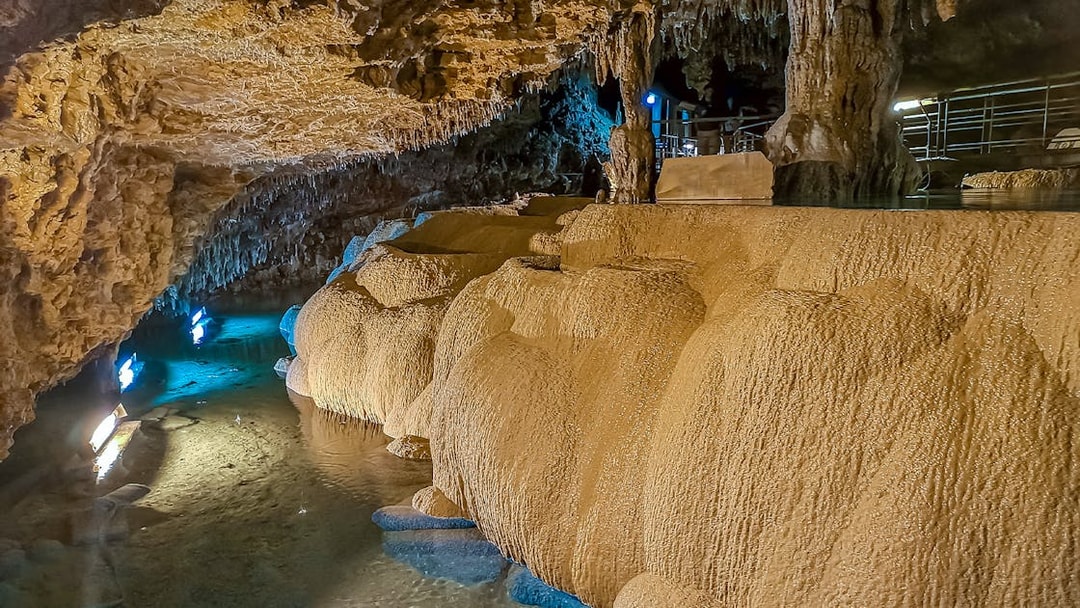 Underground limestone cave at Okinawa World with illuminated stalactites and stalagmites.