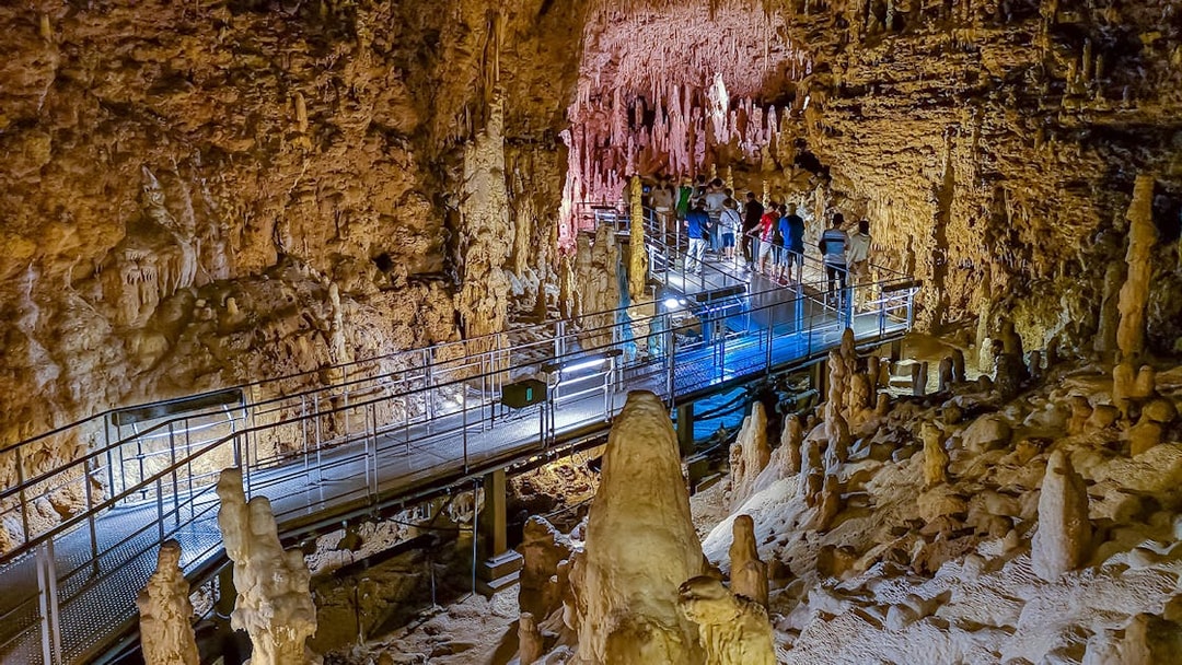 Visitors exploring stalactites and stalagmites in Gyokusendo Cave, Okinawa World.