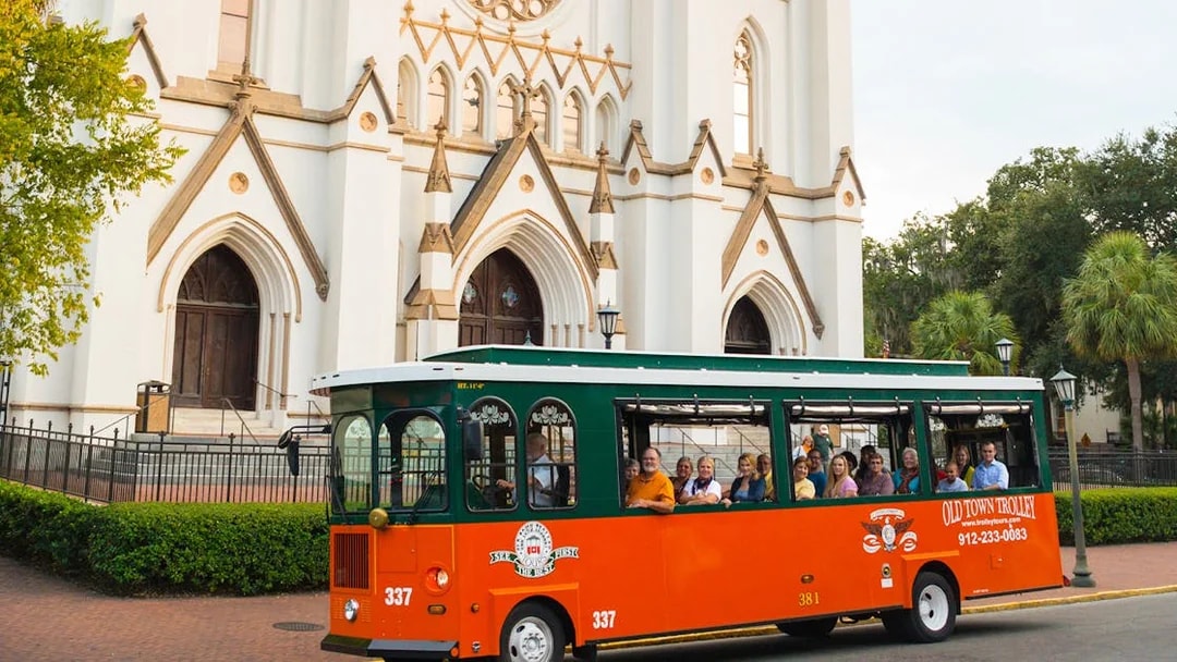 Trolley tour in front of historic cathedral in Savannah's Old Town.