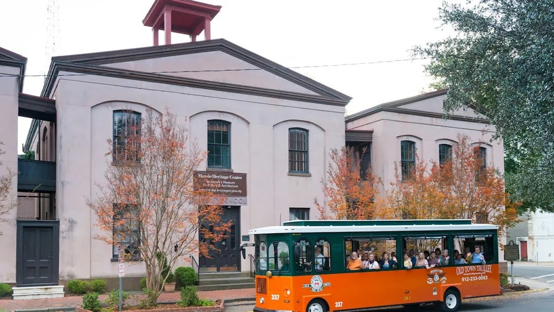 Trolley tour passing historic building in Savannah's Old Town.