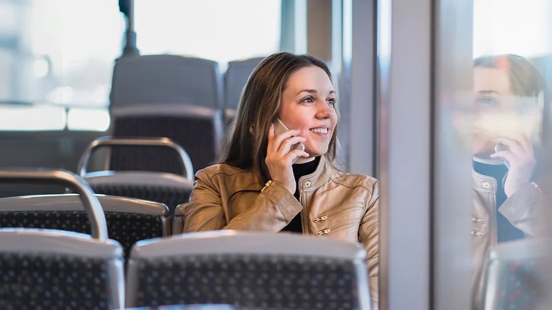 Passenger talking on phone inside airport transfer bus, Palermo.