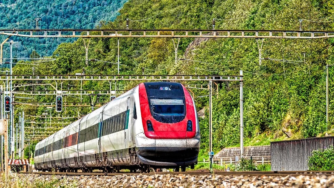 Train traveling through lush landscape, Geneva Airport to Geneva Train Station.