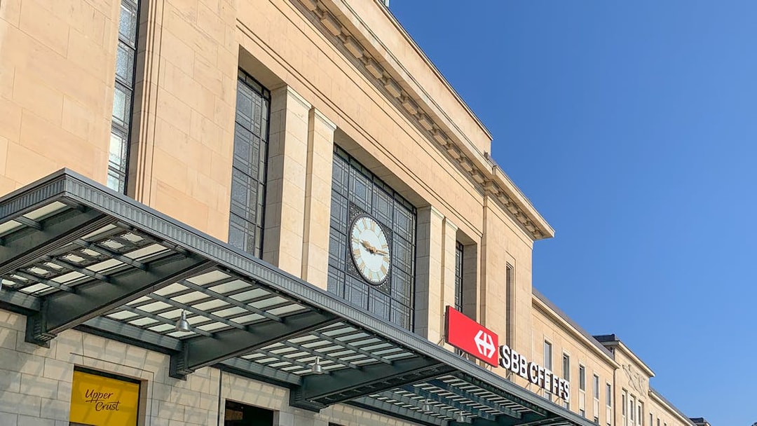 Geneva Train Station entrance with clock and SBB CFF FFS sign.