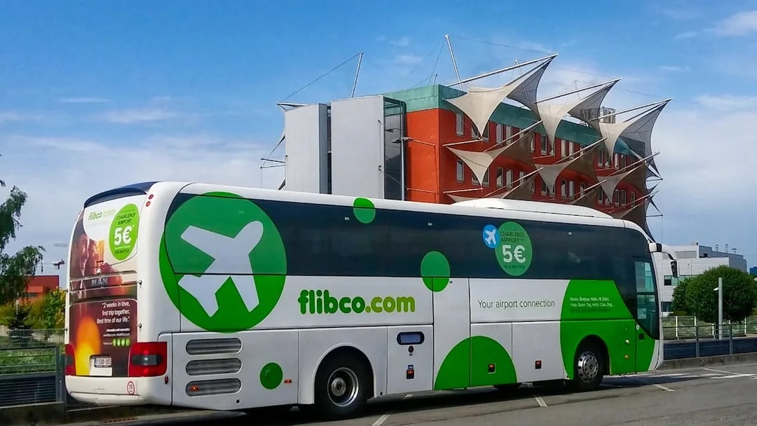 Shuttle bus for Charleroi Airport to Brussels route parked near modern building.