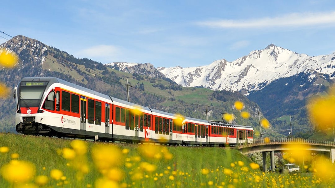 Lucerne–Interlaken Express train with snow-capped mountains in the background.
