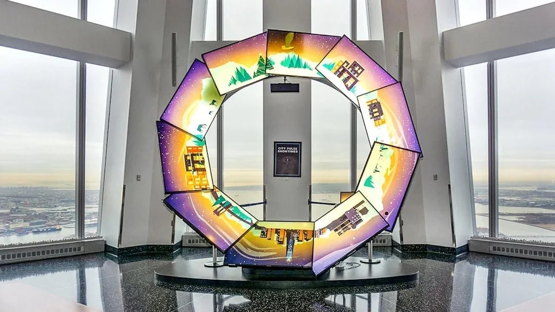 Interactive display at One World Observatory with city and nature scenes.
