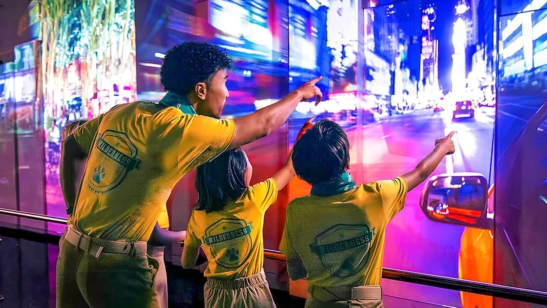 Visitors pointing at vibrant cityscape display at One World Observatory, New York.