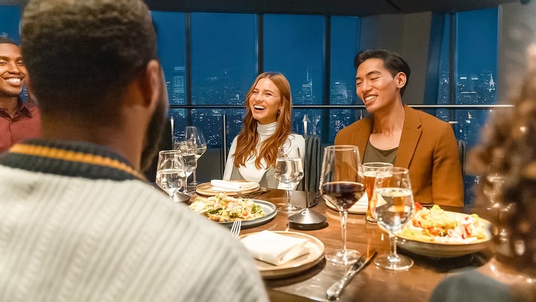 Dinner gathering at One World Observatory with city skyline view.