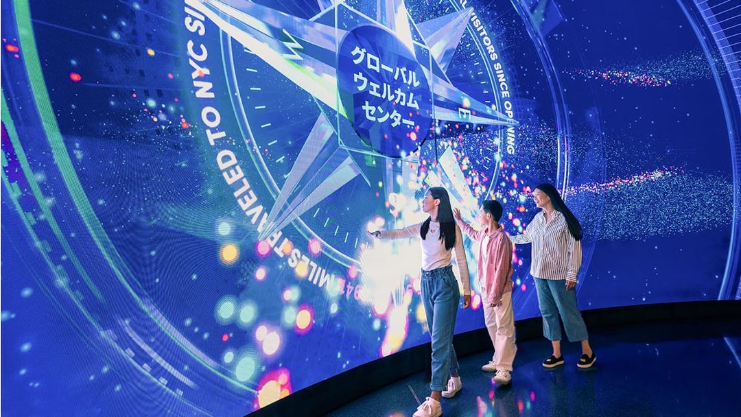 Visitors interacting with digital display at One World Observatory, New York City.