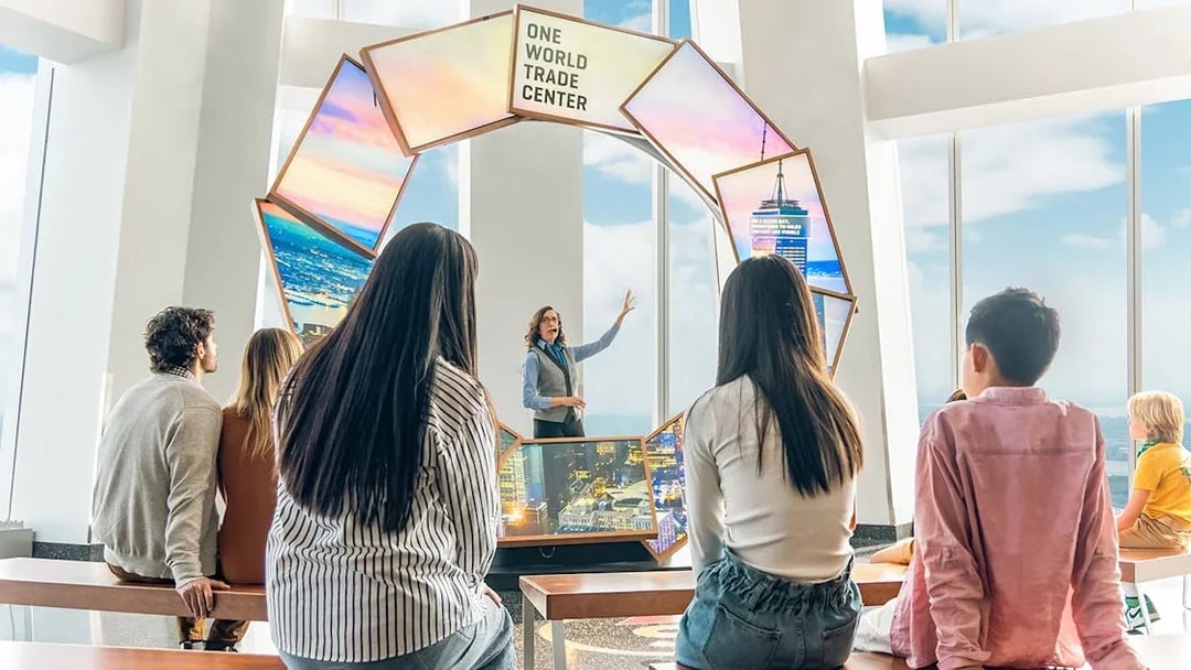 Tourists engaging with City Pulse display at One World Observatory, New York City.