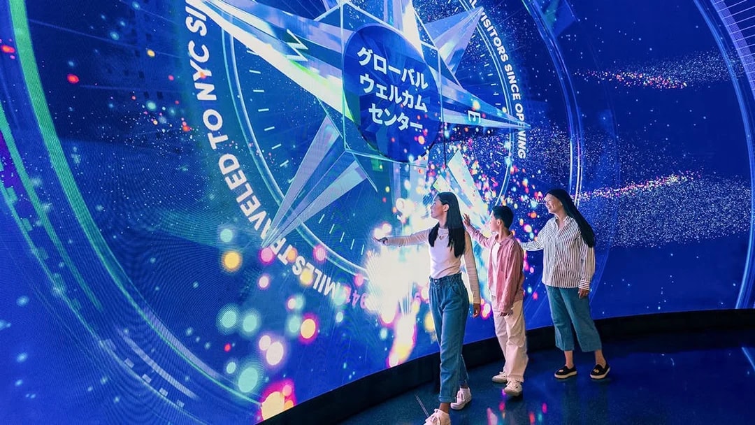 Visitors interacting with digital display at Welcome Wall, One World Observatory, New York City.