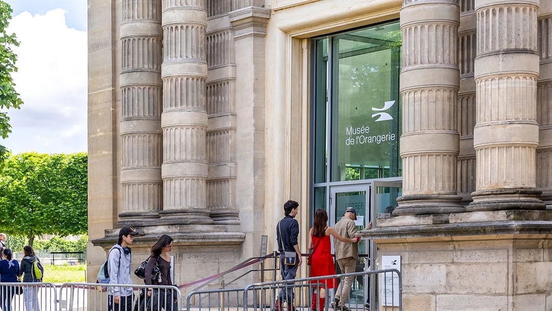 Visitors entering Musée de l'Orangerie, Paris, with its distinctive columned exterior.