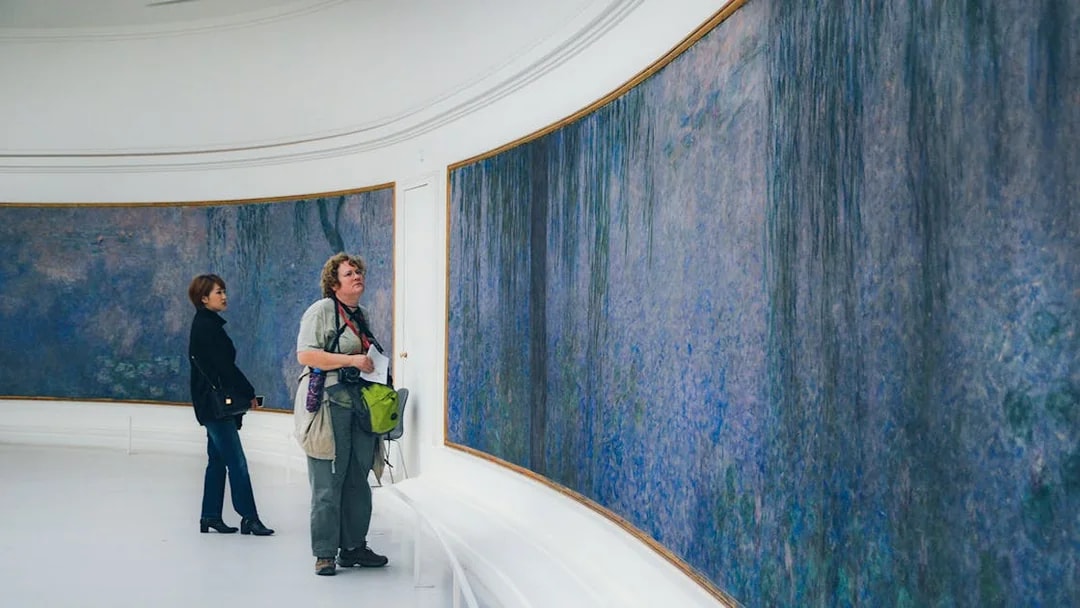 Tourist viewing Monet's Water Lilies at Orangerie Museum, Paris.