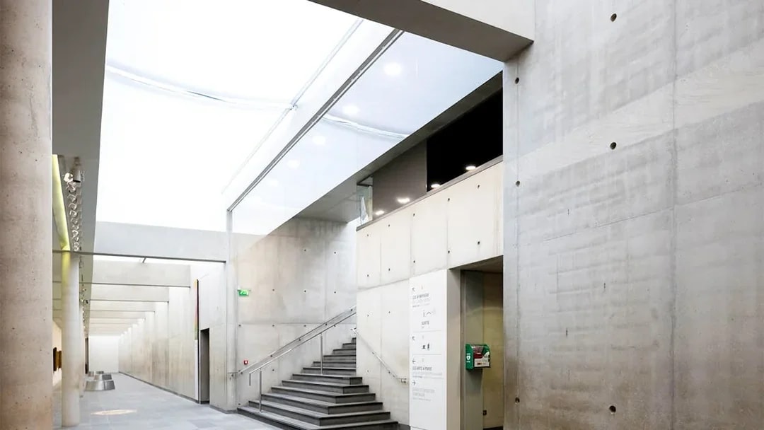 Orangerie Museum interior with modern concrete walls and staircase.