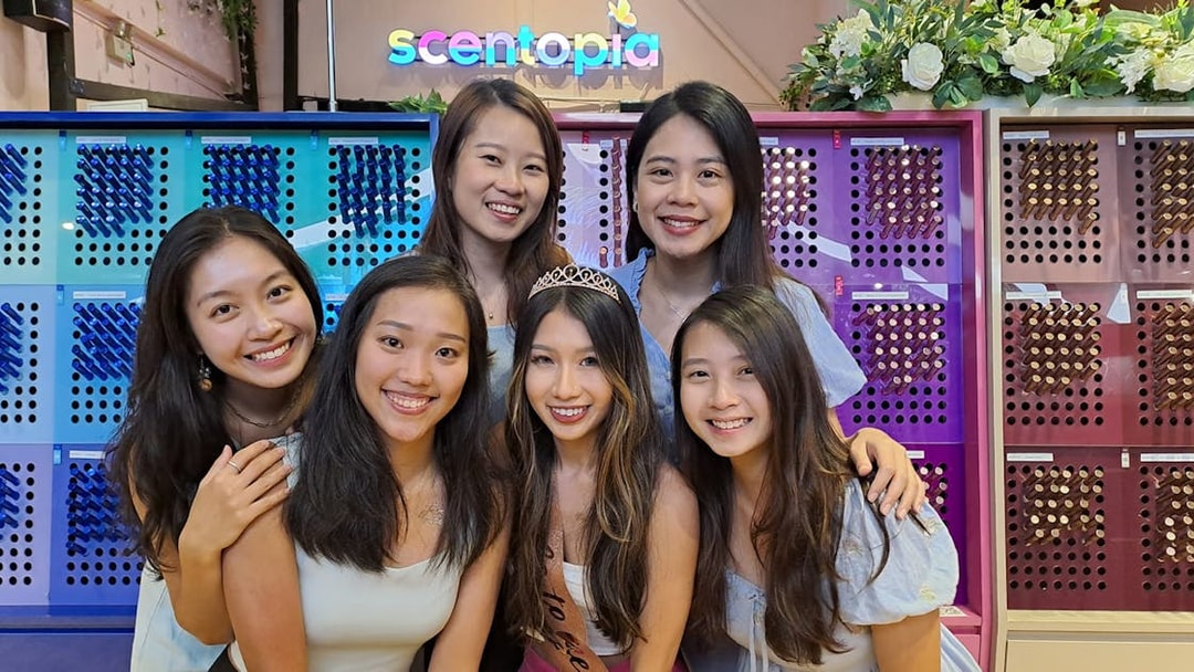 Visitors enjoying Scentopia Sentosa with colorful perfume displays in the background.