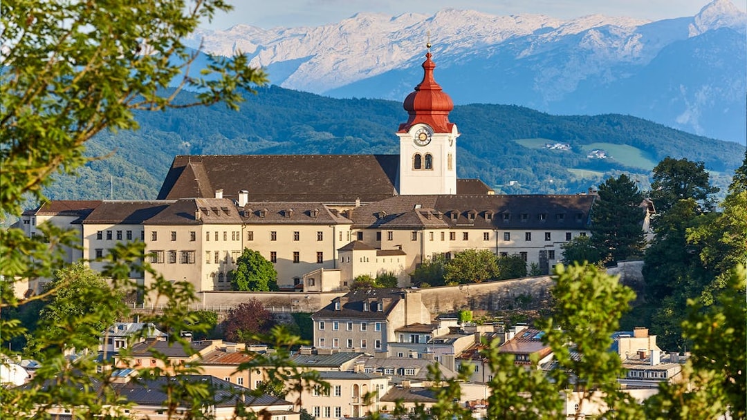 Nonnberg Abbey with alpine range backdrop in Salzburg.