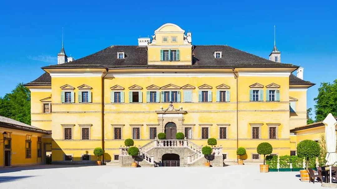 Yellow facade of Schloss Hellbrunn, a stop on the Original Sound of Music Tour from Salzburg.