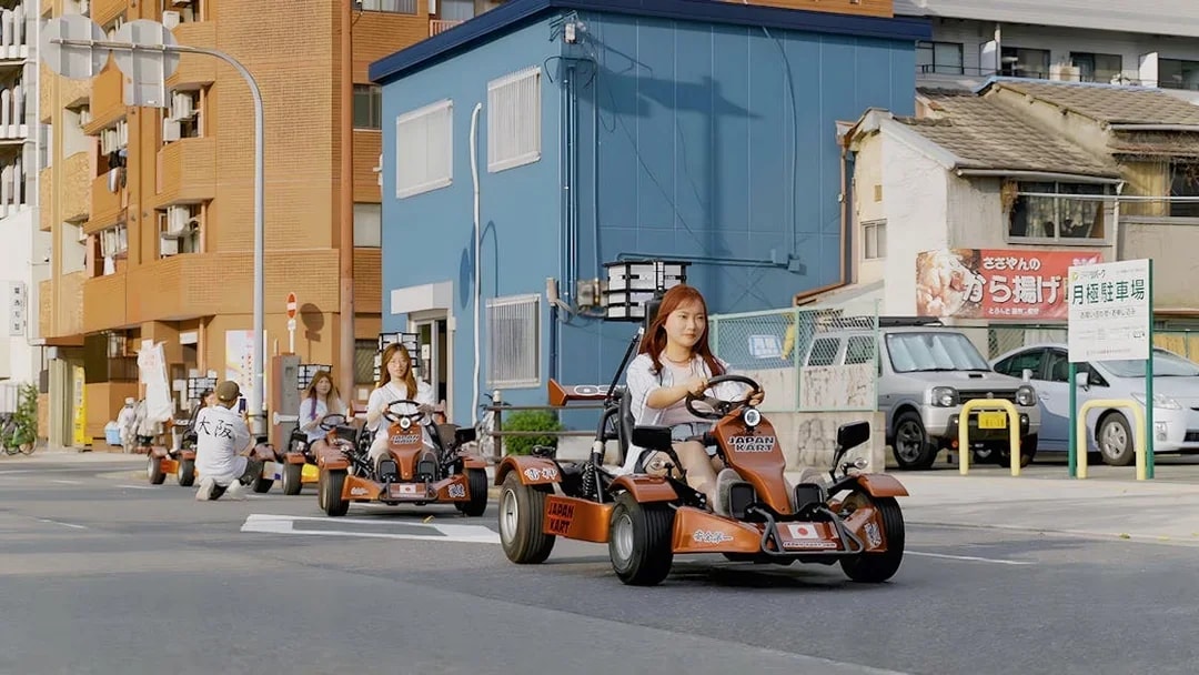 People driving go-karts on a street in Osaka during a 90-minute tour.