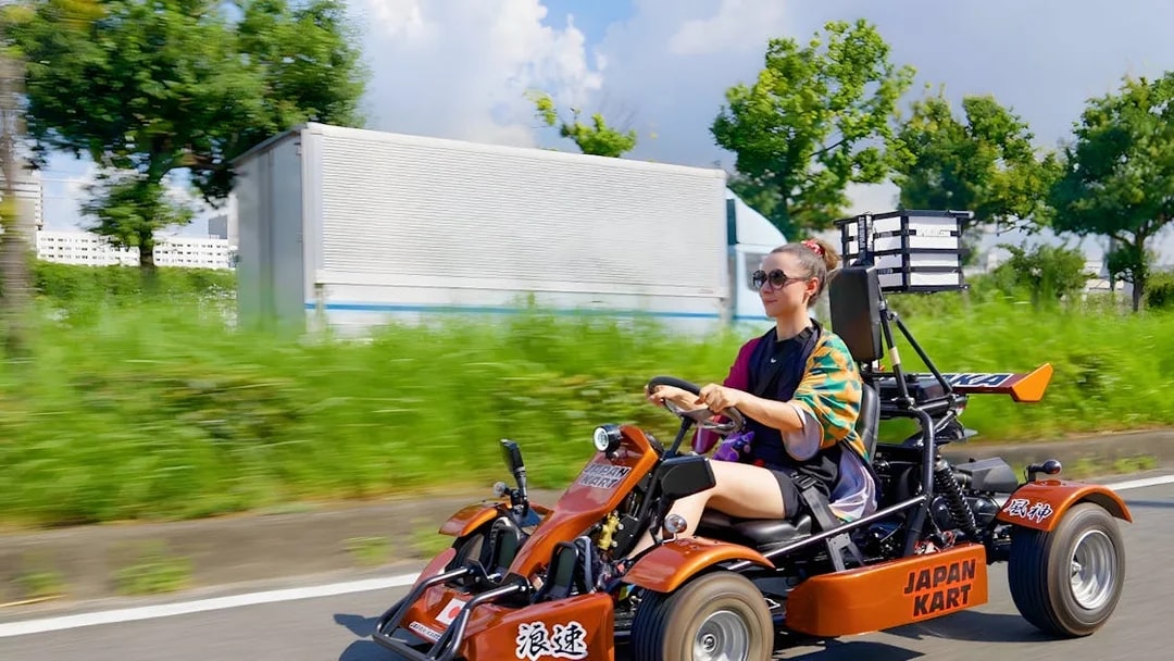 Woman driving a gokart on Osaka street during 90-minute tour.