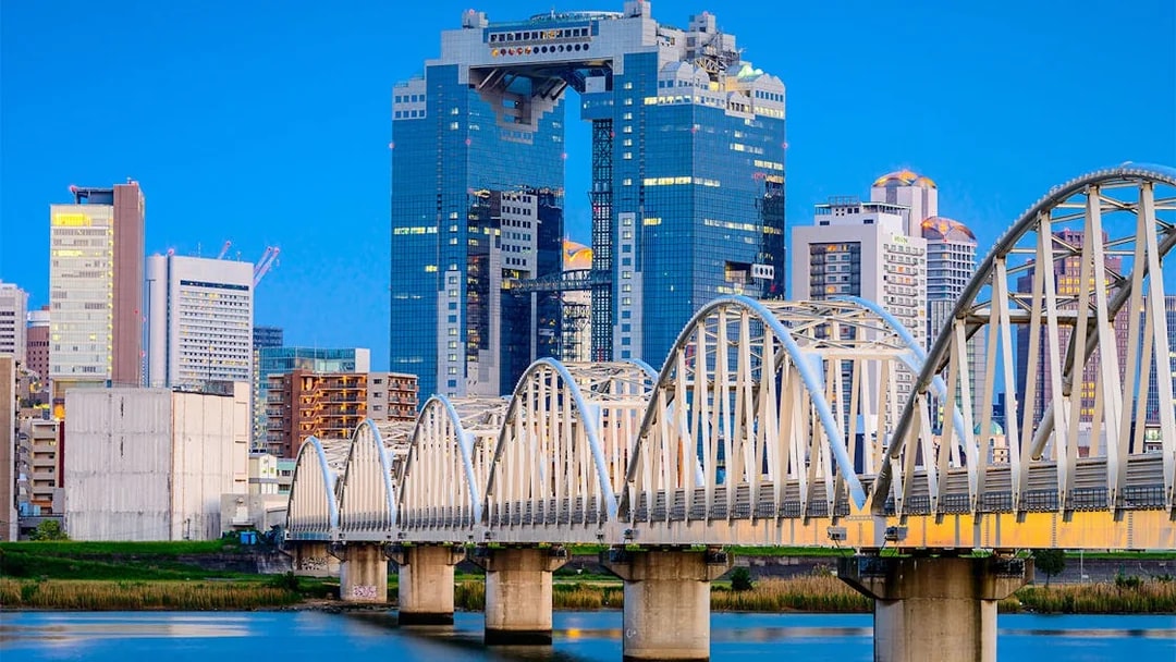 Umeda Sky Building and bridge in Osaka, Japan, viewed from the river.